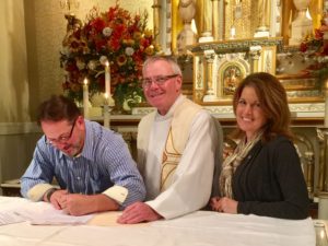 Fr. Thomas von Behren accepts the commitments of Curt and Kathy Saindon