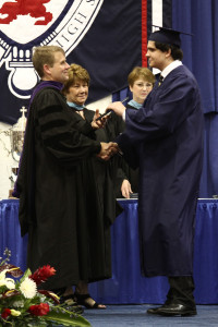 Anthony Zanocco receives his diploma from Fr. Corey Brost and Mrs. Eileen Manno, principal