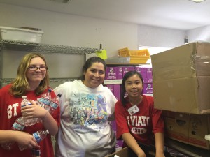 Pre-Associate Deborah Perez, center, helps lead teens at the food pantry