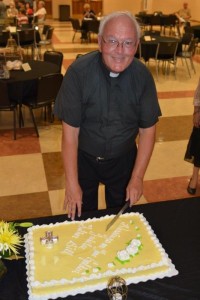 Fr. Bill Haesaert prepares to cut his cake during his 50th jubilee celebration last year