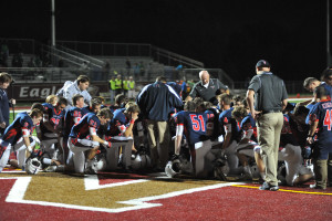 Fr. Dan Hall, center facing huddle, leads the team in prayer