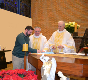 Novice Br. Peter Lamick accepts the conditions of entering the novitiate before Fr. Thomas von Behren, provincial, and Fr. John Van Wiel, his novice director