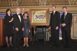 John and Mary Jo Boler and members of their family pose with the portrait that now hangs on the third floor of Saint Viator High School