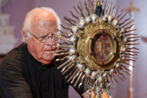 Fr. James Fanale, CSV, displays St. Anne relic. Daily Journal/John Dykstra