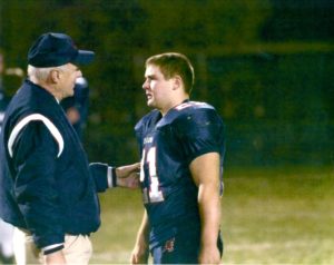 Fr. Dan Hall consoles a young Peter Lamick in 2006 after a loss in the high school playoffs