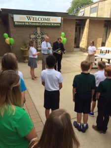 Fr. John Peeters, CSV, helps Terry Granger during the dedication on the opening day of school