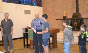 Marwan Saffaf introduces his three sons at the prayer service. Br. Michael Gosch, CSV, at left, looks on