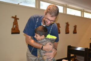 One of the boys runs up to hug Br. John Eustice, CSV