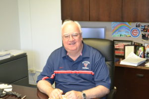 Fr. Mick Egan at his office at Saint Viator High School, surrounded by his Cubs memorabilia