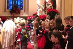 Fr. John Peeters, CSV, blesses each child's infant Jesus from their family creche